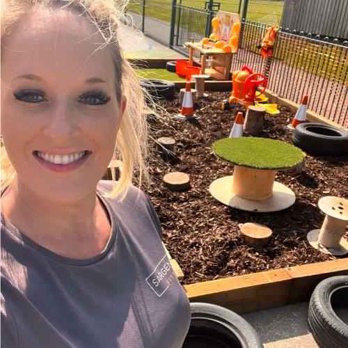 Spencer Clarke Group employee, Debbie Holden, smiling in front of a construction zone. 