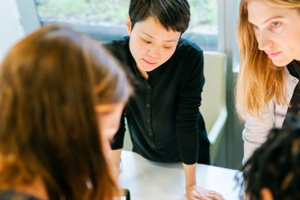 Three female professionals crowded around a table