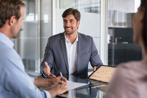 A man sat talking to two other people