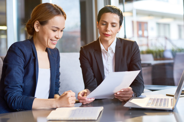 Two ladies sat looking at a piece of paper