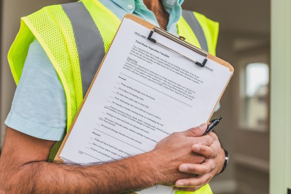 A man wearing a high vis jacket holding a clipboard