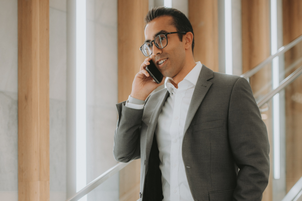 A man wearing glasses talking on the phone