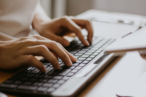 Hands typing on a computer keyboard