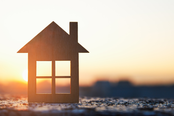 A model house sat in front of a sunset