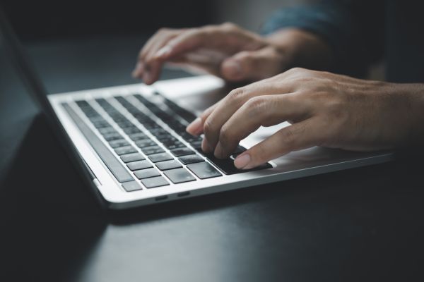 Hands typing on a laptop keyboard