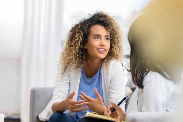 A female professional speaking to another person whilst sat down