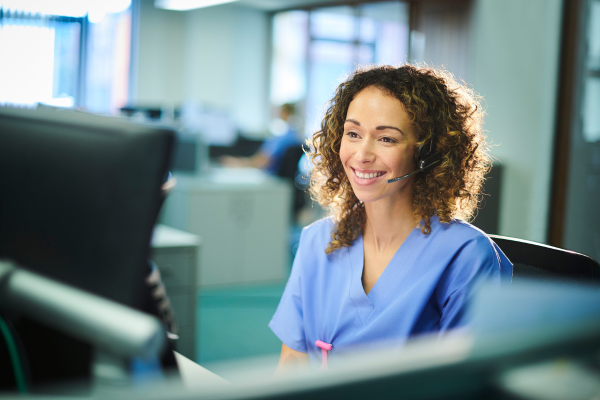 An NHS Customer Service Advisor sat at her desk