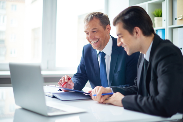 Two men sat talking at a desk