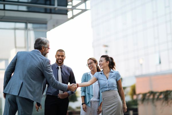 A man and lady shaking hands in front of another man and lady