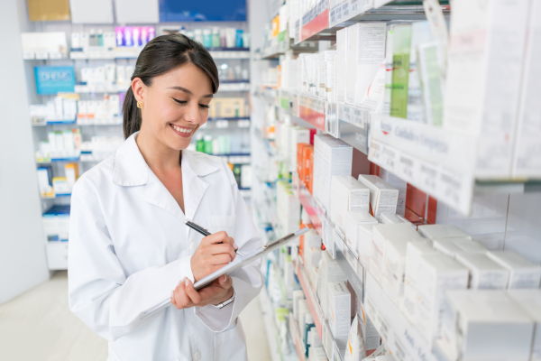 A female pharmacist making notes on a clipboard