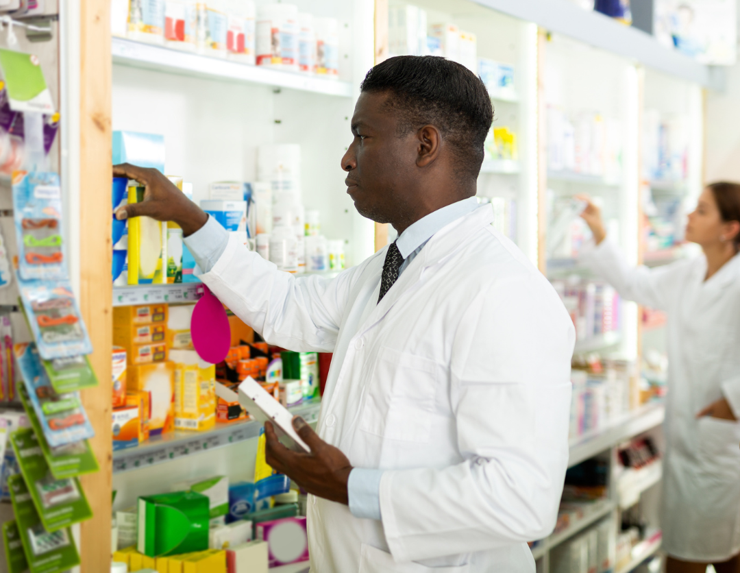 A male pharmacist stacking a shelf