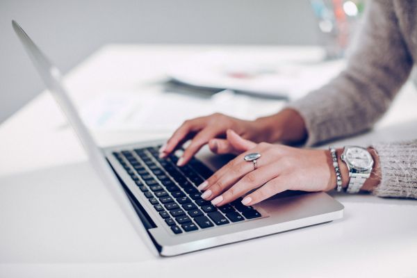 Hands typing on a laptop