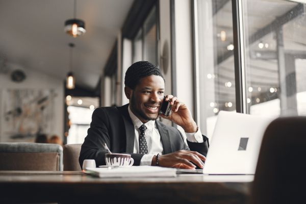 A man on the phone whilst sat at his desk