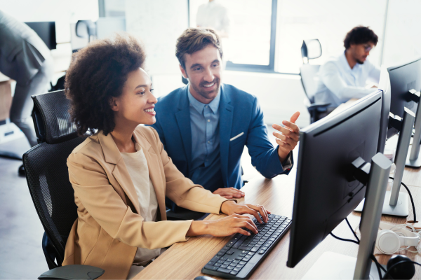 A lady and a man sat together looking at a computer screen