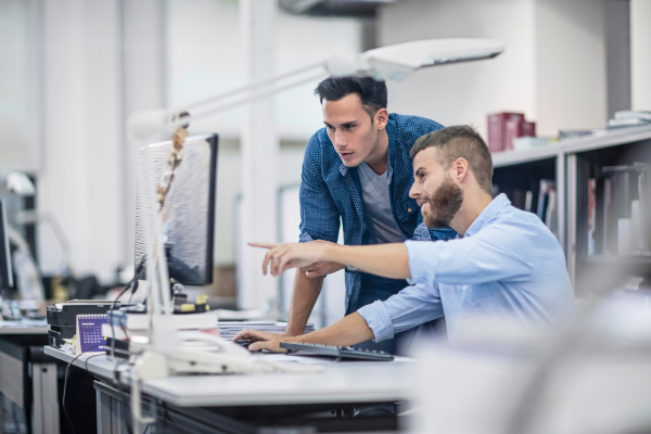 Two men looking at a computer screen in an office