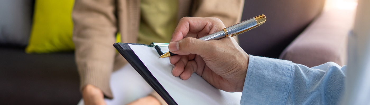 A male's hand about to write on a blank piece of paper