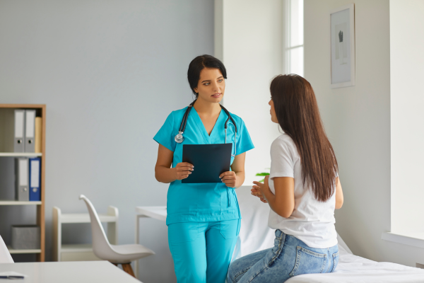 A female Nurse speaking to a female patient