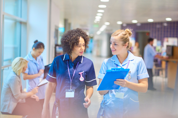 Two female Nurses walking down a hospital corridor