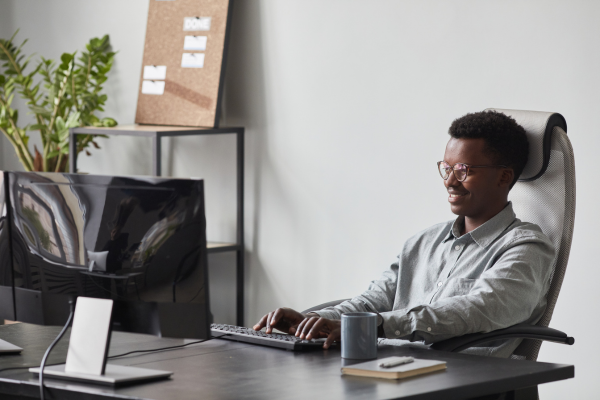 A man sat at a desk typing on a keyboard