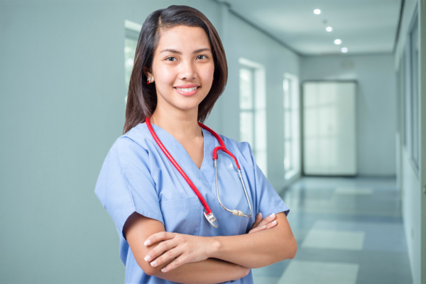 A female nursing professional stood wearing a blue uniform