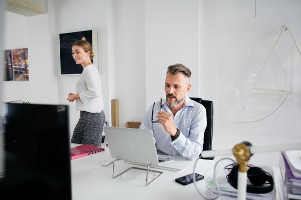 A man sat looking at a laptop