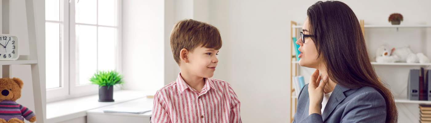 A female professional speaking to a young boy