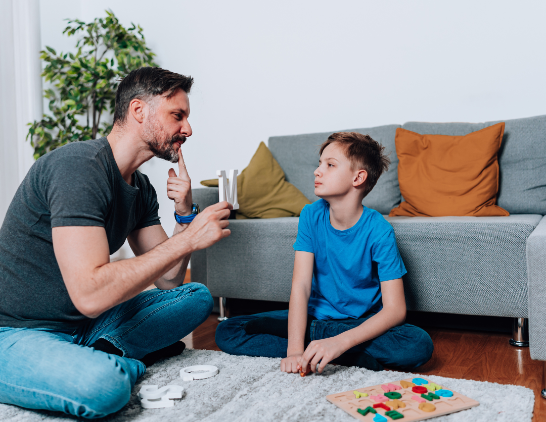 A man helping a young boy with his speech