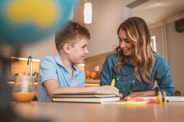 A female Speech & Language Therapist smiling at a young boy