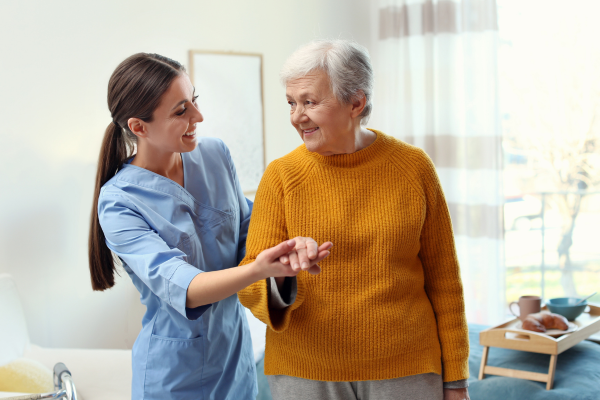 A female Support Worker helping an elderly lady