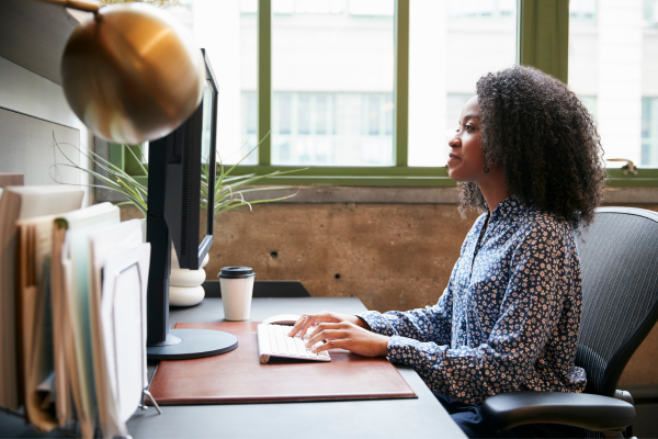 A lady sat at a desk looking at a computer screen