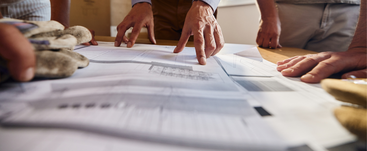 Paper laid out on a desk with hands around the outside