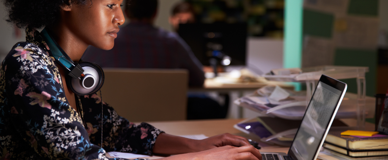 A young woman sat in front of a laptop