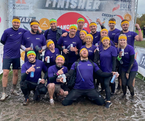 Spencer Clarke Group employees celebrating after completing Tough Mudder