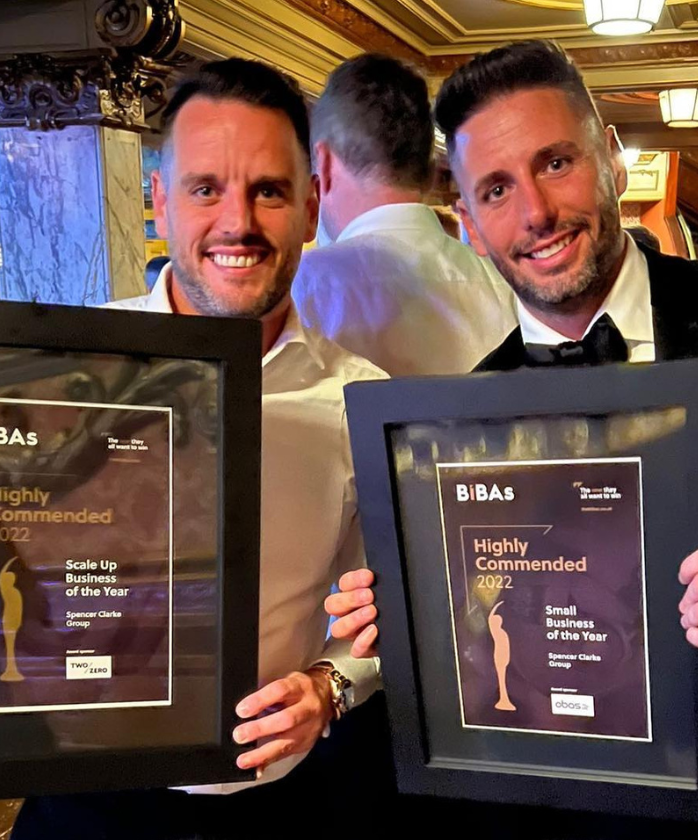 A male Spencer Clarke Group employee and the Managing Director holding awards certificates