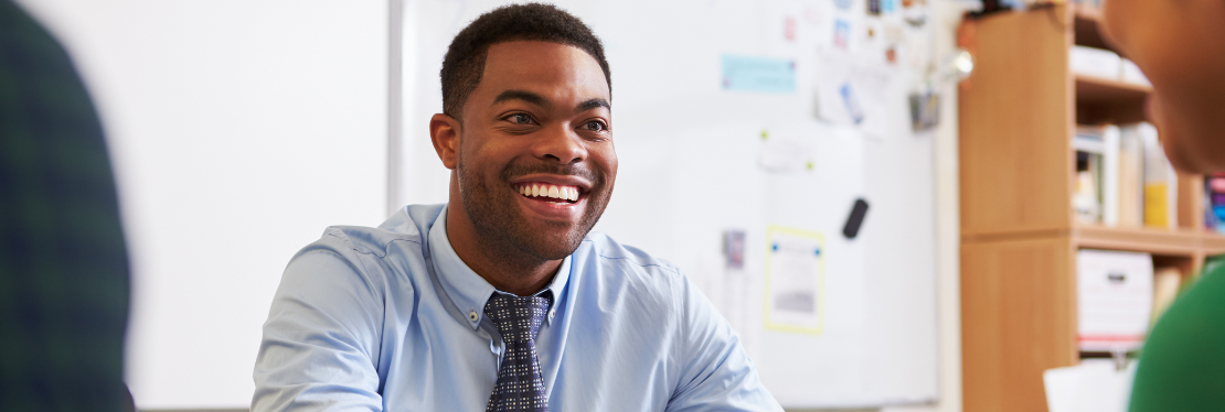 A man in a blue shirt smiling