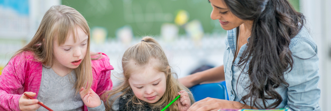 A Teacher helping two young pupils