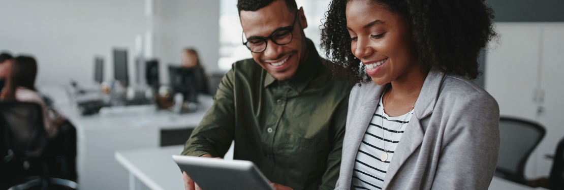 A man and women looking at a touch screen device