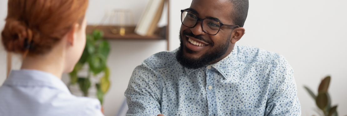 A man smiling at a woman