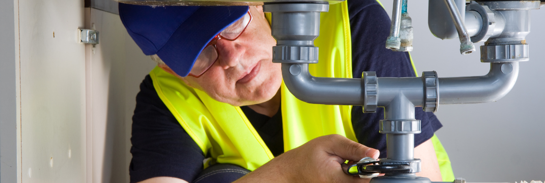 A male plumber fixing a pipe