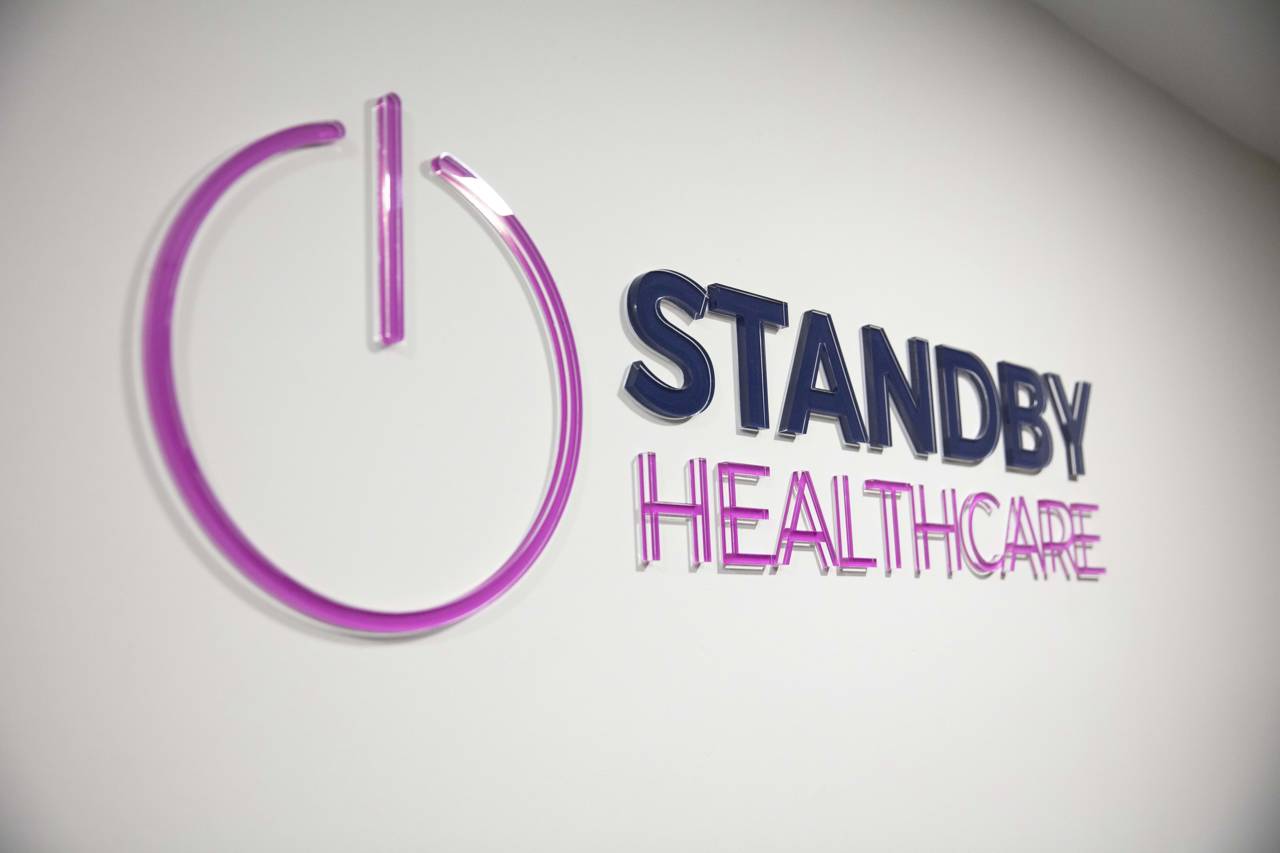Standby Healthcare sign on a white wall