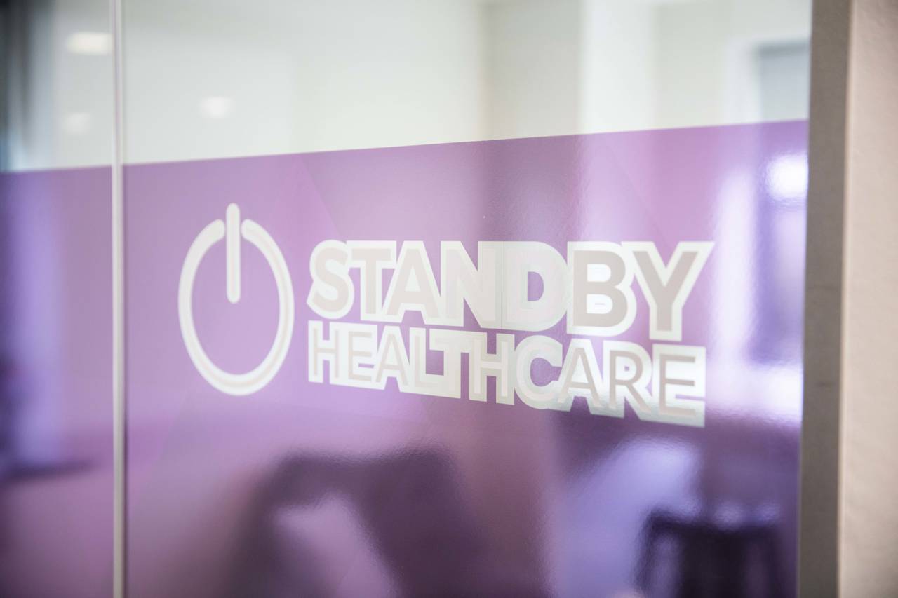 Purple glass with a Standby Healthcare sticker on it