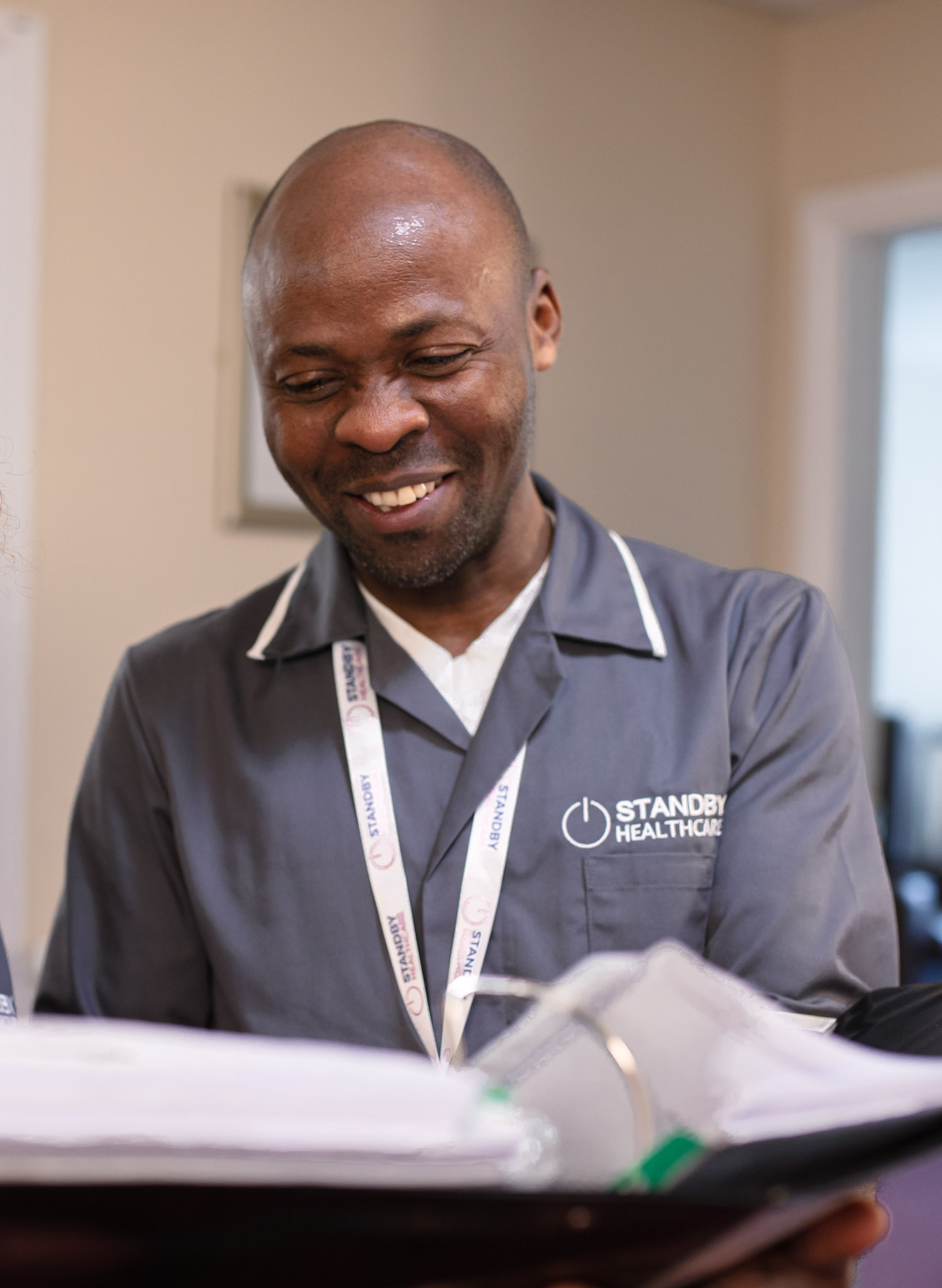 Care worker smiling down at documents in a file.