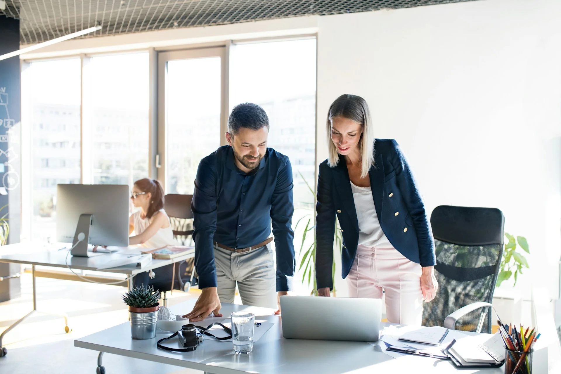 three-attractive-young-business-people-in-the-office-working-together-consulting-a-project-