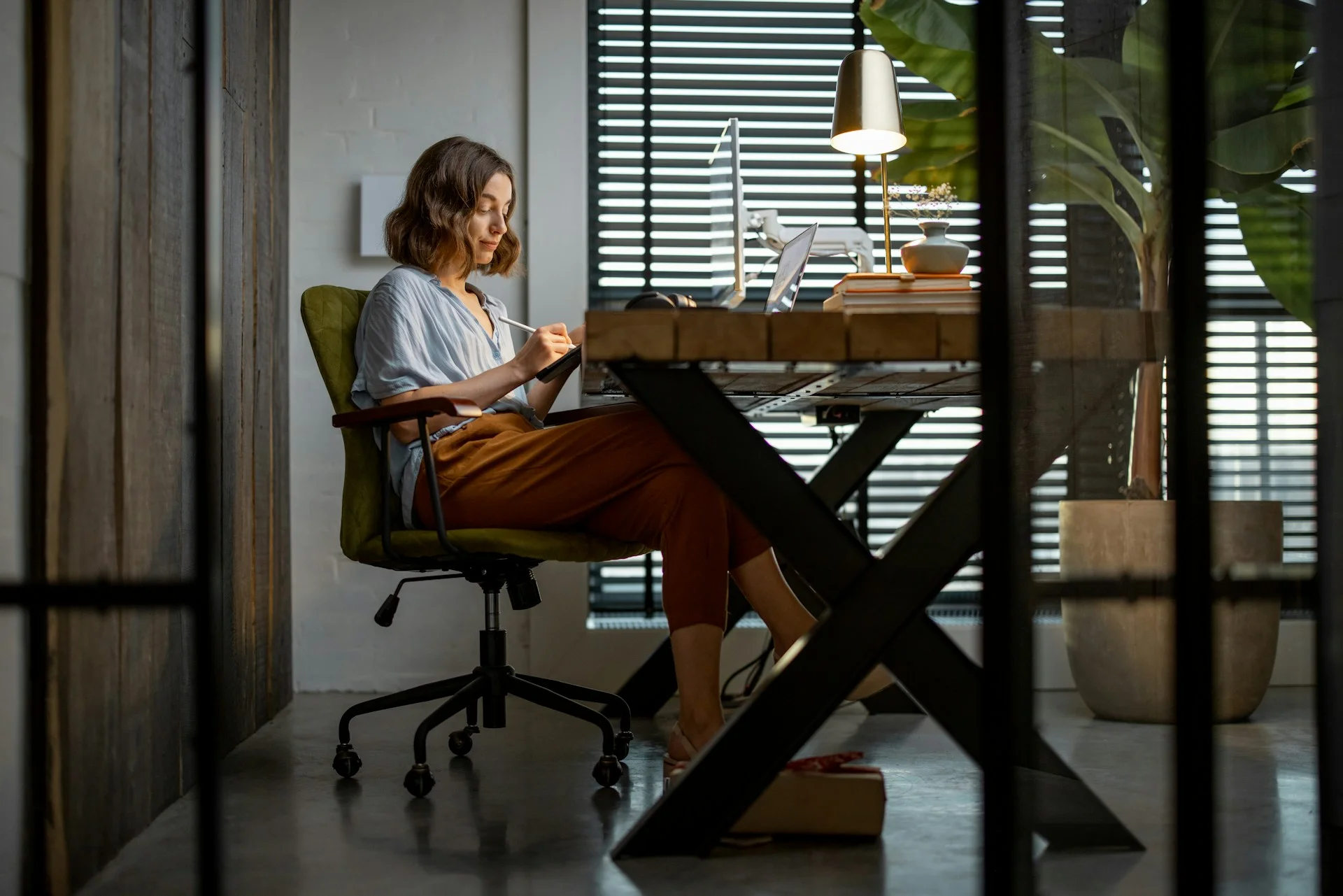 creative-woman-working-on-a-touchpad-at-the-cozy-and-stylish-home-office-full-shot