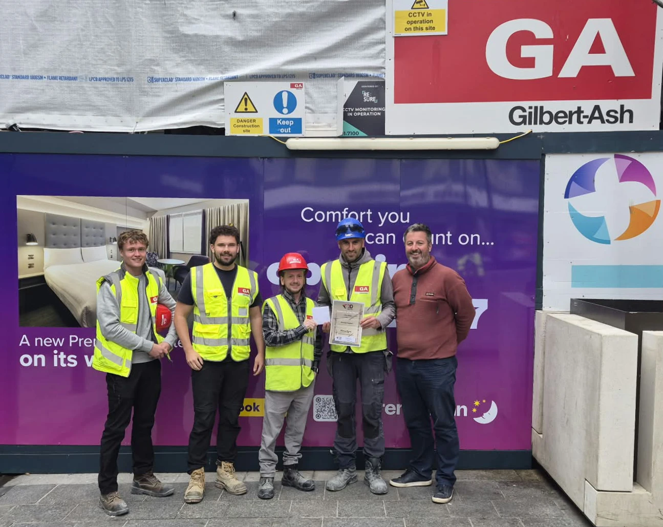 Nicolae displays his award alongside Darran and some of the site management team