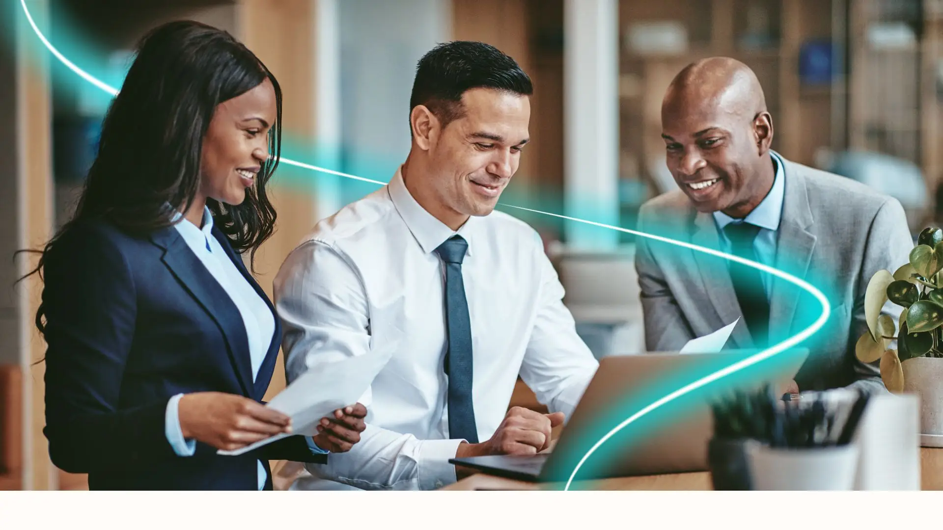 Three business professionals smiling and collaborating around a laptop in an office setting with blue neon light trails.
