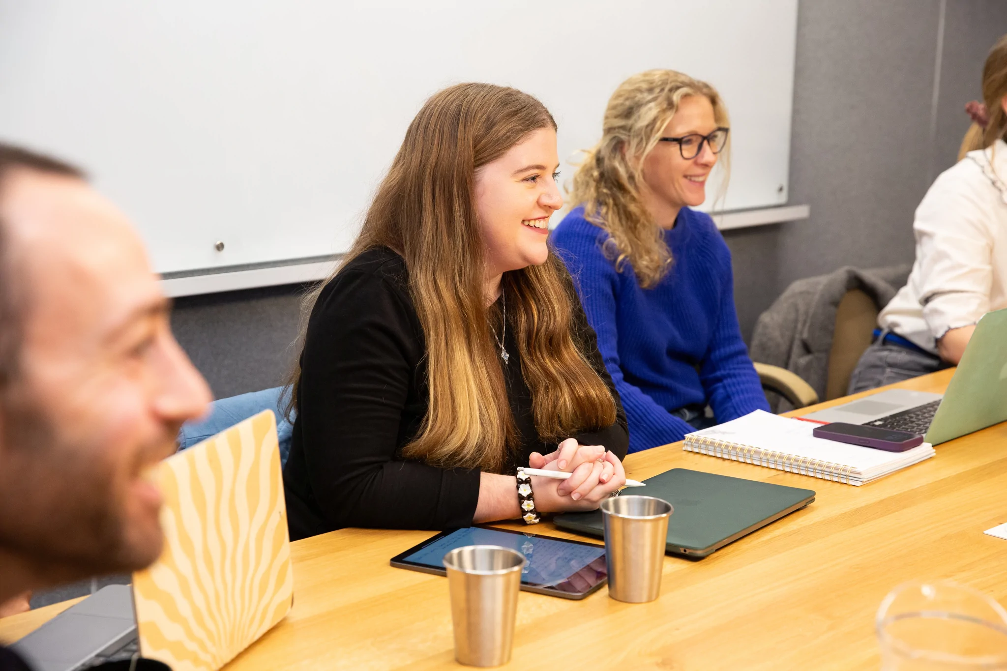 Colleagues sat smiling in a meeting
