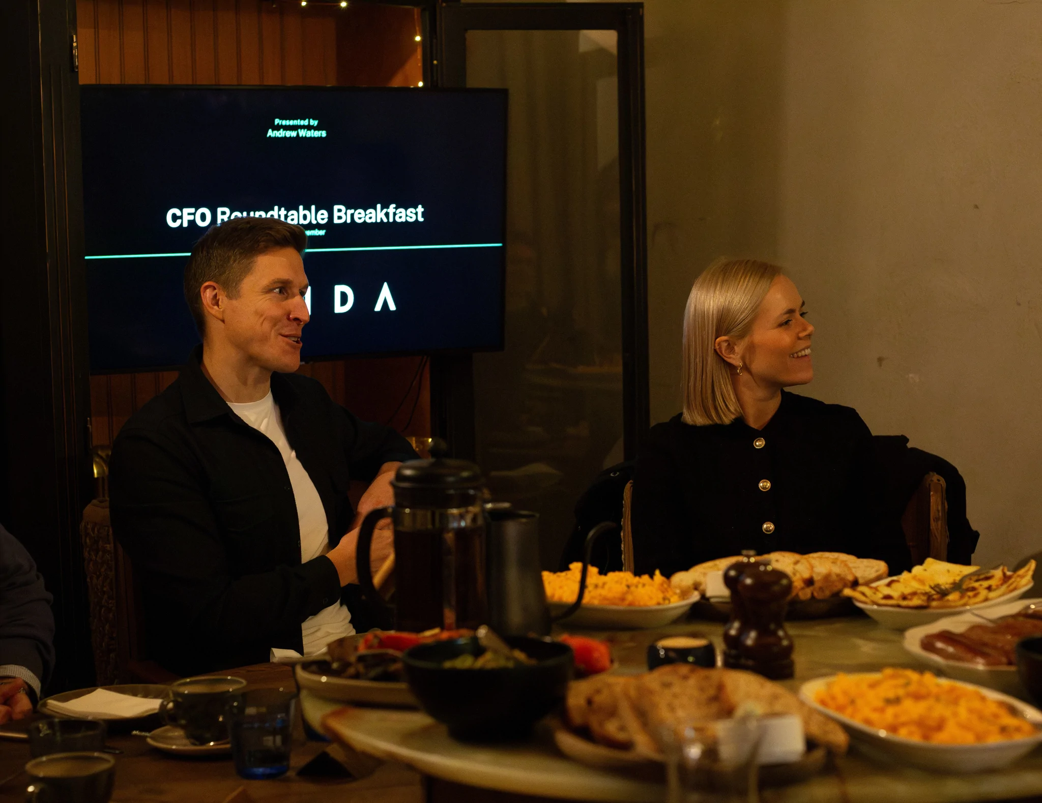 CFO and Founder smiling at a breakfast roundtable