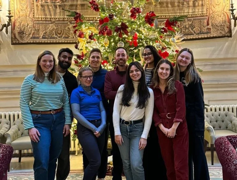 Company photo posing in front of a christmas tree